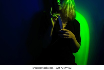 Nail photo content over multicolor vivid neon light color background  Portrait cute blonde manicurist in working form and tools in hand 