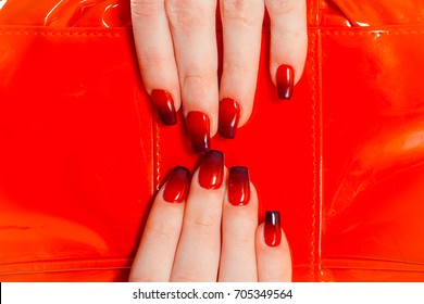 Nail Polish  Art Manicure  Modern style red black gradient Nail Polish  Stylish Colorful trendy Nails beauty hands isolated red bag as background