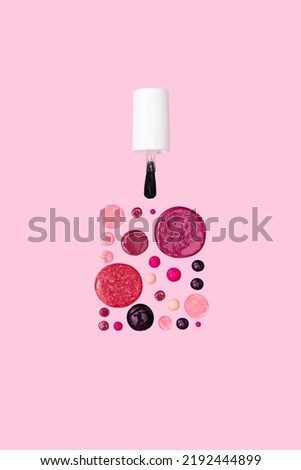 Nail polish bottle mockup crated from drops of red and pink nail polish on pink background. Nail polish concept