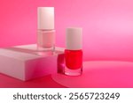 Nail polish in bottles on pink background