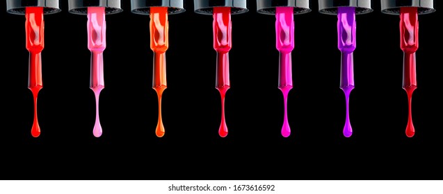 Nail polish. Colorful various nailpolish drops on brush, isolated on black background. Fashion beautiful nail art, Design of female colourful nailart, Dripping colored UV nail varnish