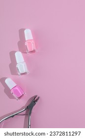 Nail polish and cutter on pinkbackground, manicure set
