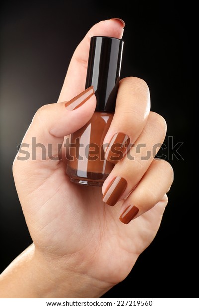 Nail polish in hand,\
close-up