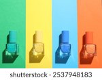 Nail polishes in bottles on color background, flat lay. Space for text