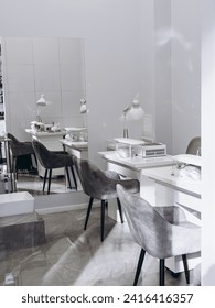 Nail salon bright interior. View of modern manicure shop. Inside beauty studio with white design. Clean empty trendy nail salon.