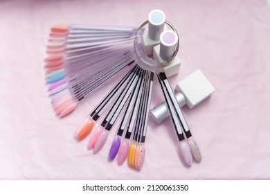 Nail Salon Table With Manicure Tools And Nail Polish Bottles On Pink Background. Flat Lay, Top View.  Beauty Treatment Concept