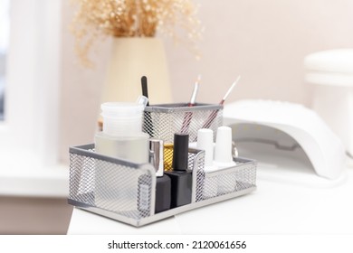 Nail Salon Table With Manicure Tools And Nail Polish Bottles On Green Background.  Beauty Treatment Concept