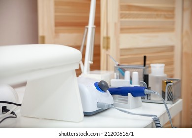 Nail Salon Table With Manicure Tools And Nail Polish Bottles On Green Background.  Beauty Treatment Concept