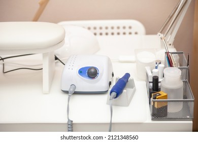 Nail Salon Table With Manicure Tools And Nail Polish Bottles On Green Background.  Beauty Treatment Concept