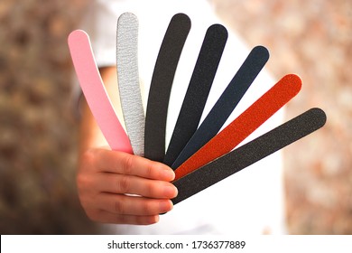 Nail technician holding a fan of various nail files for a manicure or pedicure in a spa