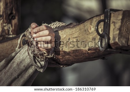 Nailed hand on wooden cross. Crucifixion of Jesus Christ.