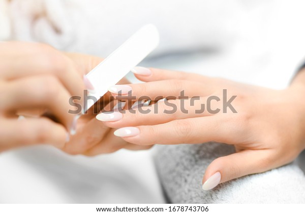 Nails manicure detail with file or brush item.\
Woman beautiful nail care\
process.