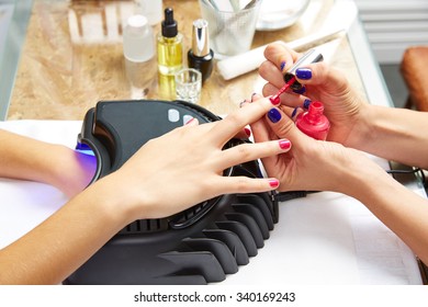 Nails Painting With UV Dry Lamp In Blue Light Woman Hands At Nail Salon