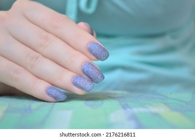 Nails With Pixie Dust Nail Polish In Front Of A Turquoise Background