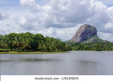 Nairuku Mountain in Nampula, Mozambique. A cloudy day in the savannah, along the banks of a dam. An expanse of water immersed in the green forest.