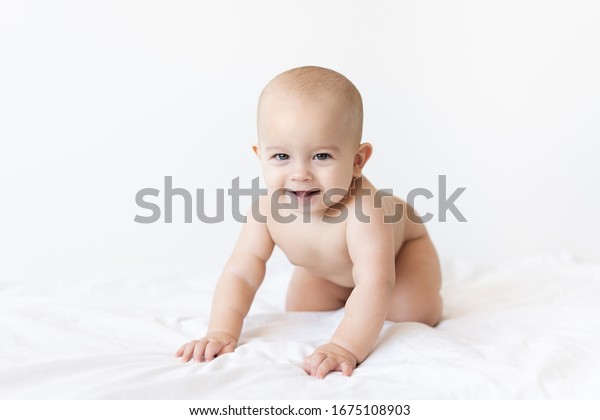 naked baby boy smiling on a white blan