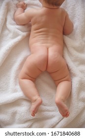 Naked Baby Butt And Legs On White Bed. Dry And Healthy Body And Skin,