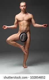 Naked guy with a hat that is between his legs