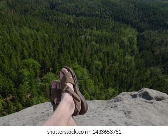 Naked Hairy Male Legs With Leather Sandals Rest While Trail. Person Enjoy Fantastic View Into Wild Landscape And Gains Again Power.