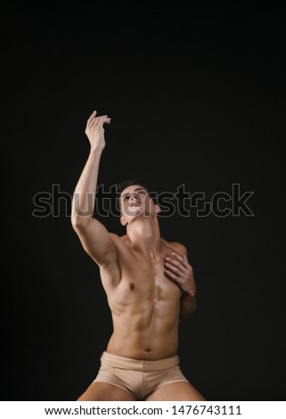 Naked man pulling hand up and looking after