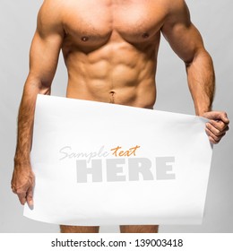 Naked muscular man covering with a banner  (copy space) isolated on white