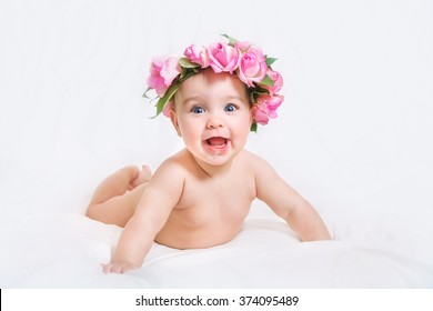 Naked newborn baby with a wreath of flowers