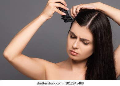 Naked Sad Brunette Long Haired Woman Shaving Head With Electric Razor Isolated On Black