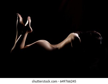 Naked woman sexy silhouette, sensual nude female body on a dark background