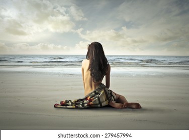 Naked Woman Sitting On The Sand