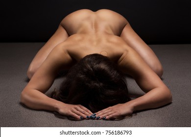 Naked Woman Yoga On Black Background. Fine Art Photo Of Female Body.