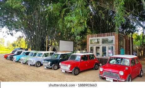 Nakhon Nayok, Thailand - December 5, 2020: Many Austin Mini Cooper Or Classic Car Parked On Street With Bamboo Forest And House Or Home Background With Copy Space. Group Of Vintage Or Retro Vehicle. 