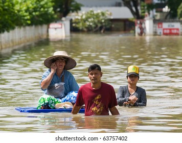 NAKHON RATCHASIMA - OCTOBER 24: People floating their belongings while wading through deep water during the monsoon flooding of October 24, 2010 in Nakhon Ratchasima, Thailand.