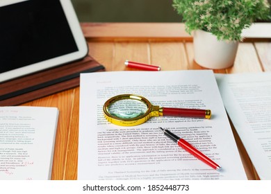 Nakhon Ratchasima, THAILAND-November 11, 2020: new golden maginifier on proofreading paper on wooden table with office supply