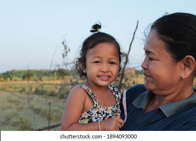 Nakhon Sawan, Thailand 12 01 January 2021 An Old Woman Holding A Black Child Looking At The Camera In Surprise.