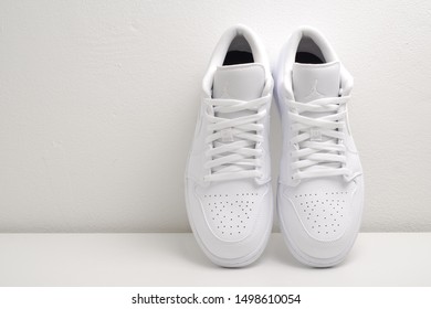 Nakhonpathom, Thailand - Sep 8, 2019 : Nike Air Jordan 1 Retro Low 'Triple White'. Sneaker With White Wall Background. Sneaker For Retro Lift Style.