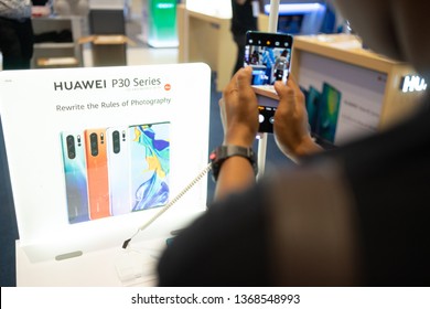Nakhonratchasrima,Thailand- April 13, 2019:The Huawei symbol. Huawei mobile smartphone are shown on retail display in electronic store. New P30 logo in the background.