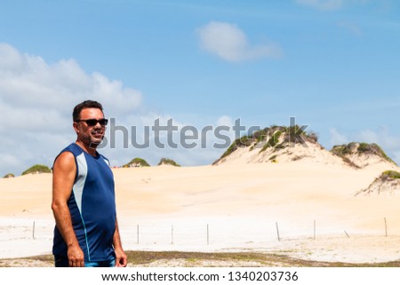 Naldo posing for photos in Natal with Genipabu Dunes at background.