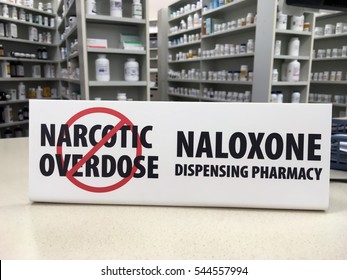 Naloxone Pharmacy Sign On Counter Showing The Pharmacy Now Sells Over The Counter Naloxone Injections To Prevent Drug Overdose