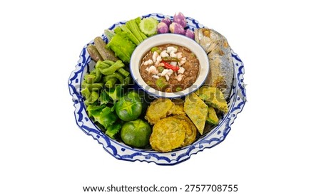Nam Phrik Kapi, authentic Thai shrimp paste dip served with fried mackerel and assorted vegetables, isolated on white.