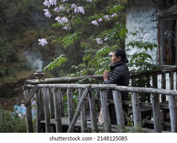 Namche Bazar,  Nepal -11-012021: Old Woman Praying Outside Of Own House In Garden