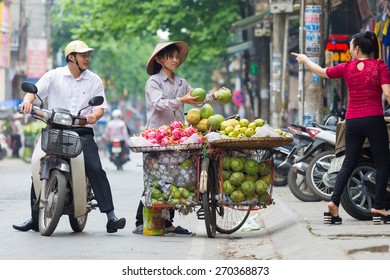 NAMDINH, VIETNAM - APRIL 18, 2015 - Unidentified women selling fruit in the street. This kind of street vendor is very popular in VIETNAM.