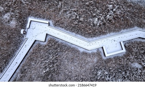 Namdong-gu, Incheon, South Korea - February 1 2022: Aerial And Top Angle View Of Snow Covered Wooden Deck Trail With Footprints And Reed Grass At Wetland Of Incheon Grand Park
