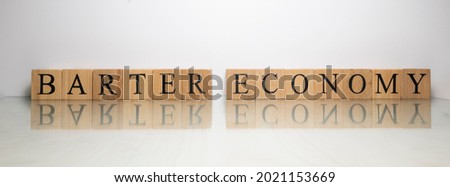 The name Barter Economy was created from wooden letter cubes. finance and illegal. close up.