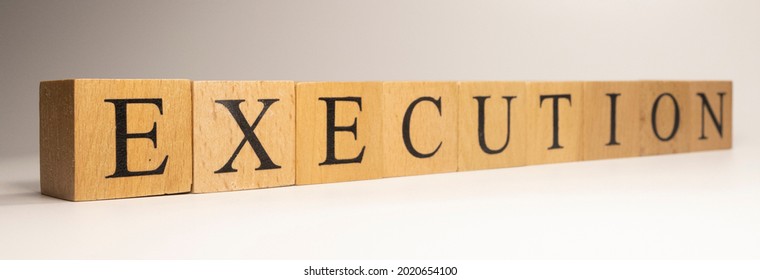 The name Execution was created from wooden letter cubes. Economics and finance. close up.