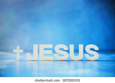 Name JESUS made with cement letters on blue light marble background. Copy space. Biblical, spiritual or christian reminder.