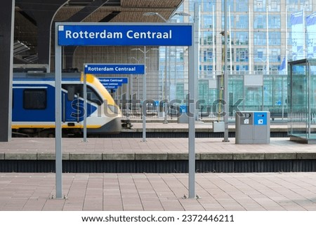 Name signs in droste effect with trains on Rotterdam Centraal Sttion Platform in the Netherlands