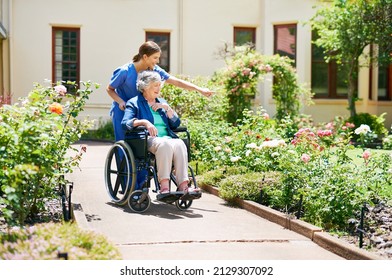 Naming the flowers as they go. Shot of a resident and a nurse outside in the retirement home garden. - Shutterstock ID 2129307092