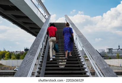 Namur, Wallon Region, Belgium, 07 28 2022 - Black And White Student Walking Up The Stairs Of The Pedestrian Bridge