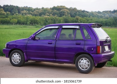 Nan Province, Thailand : September 15th 2020  : Violet Ford Festiva Car Parked On The Road With Paddy Field. 