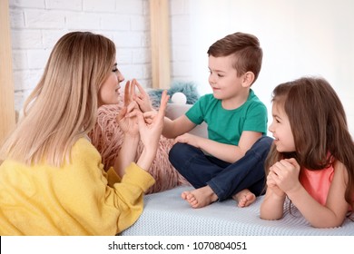 Nanny And Little Children Playing At Home